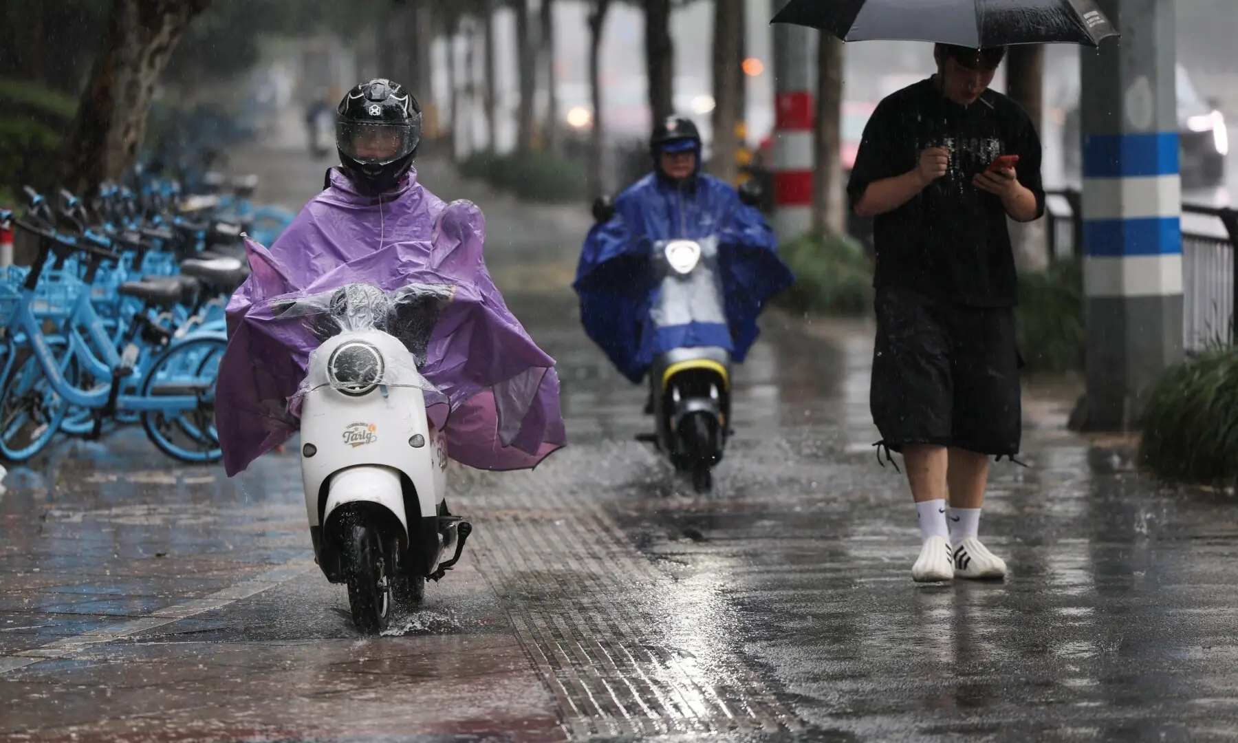 People ride electric scooters in the rain as Typhoon Bavi approaches, in Wenzhou, Zhejiang province, China July 11, 2026. —Reuters