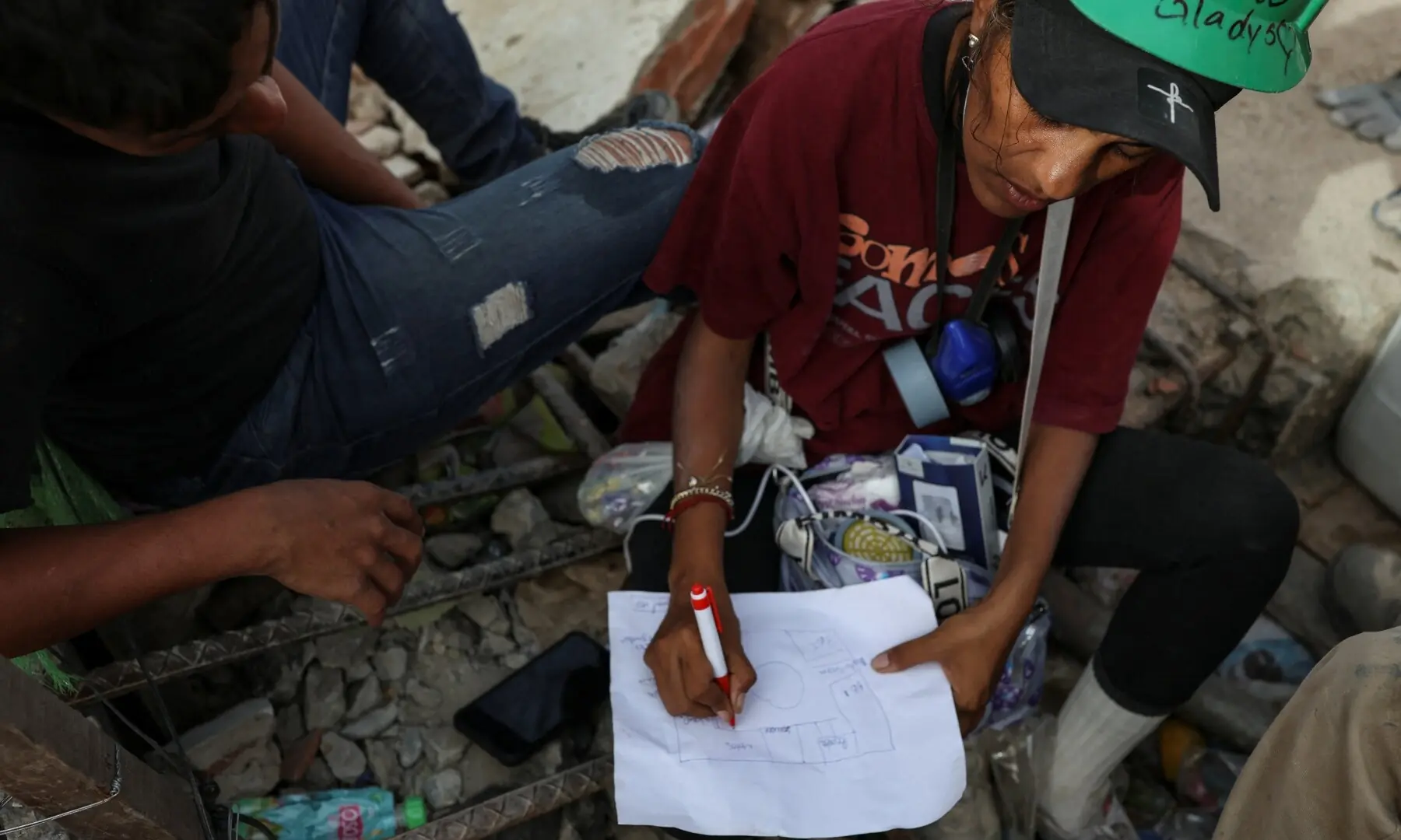A rescuer sketches a floor plan indicating where the family of Jimmy Gamboa was located before a building collapsed following the June 24 earthquakes, in La Guaira, Venezuela, July 10, 2026. — Reuters