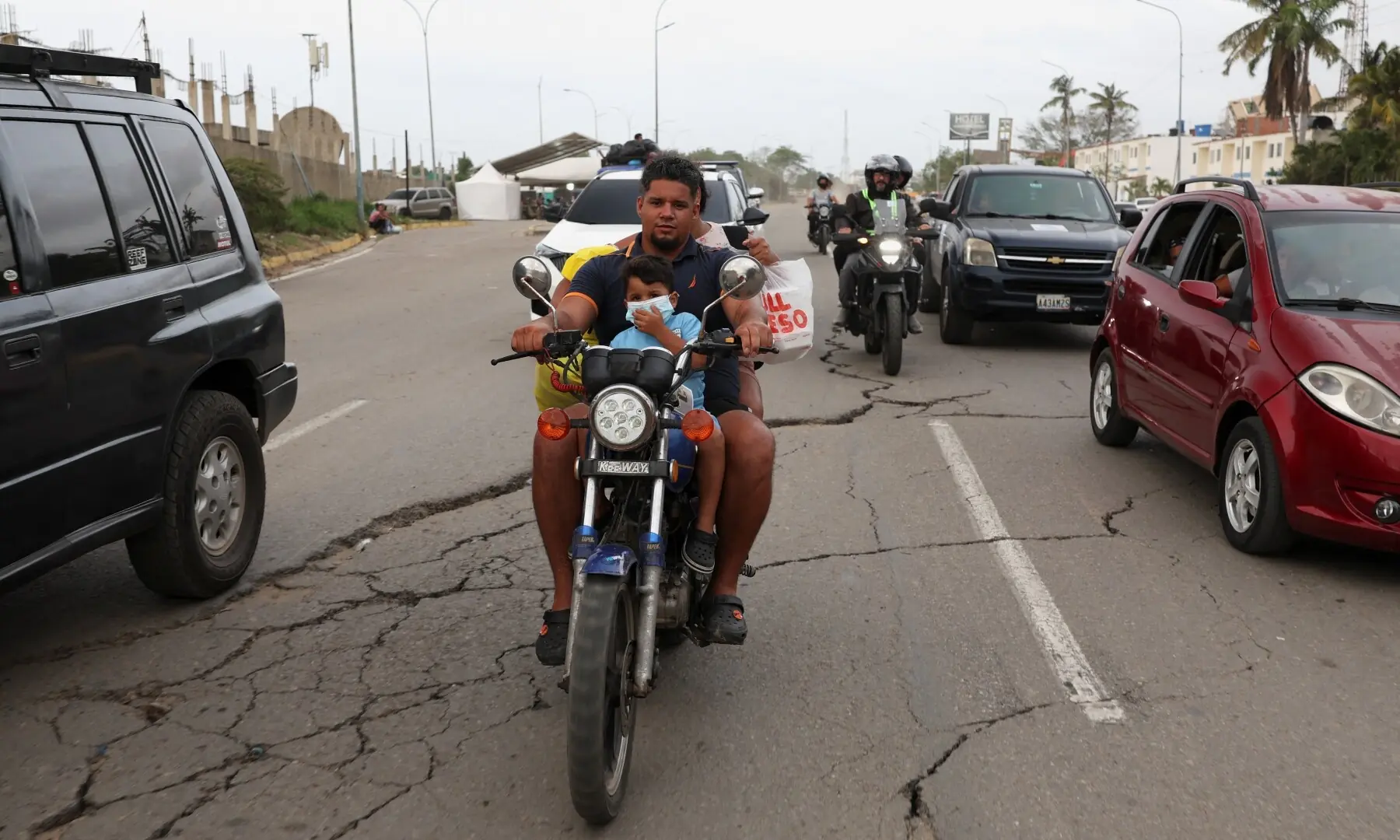 A person rides a motorcycle with a child along a damaged road following the June 24 earthquakes, in La Guaira, Venezuela, July 10, 2026. — Reuters