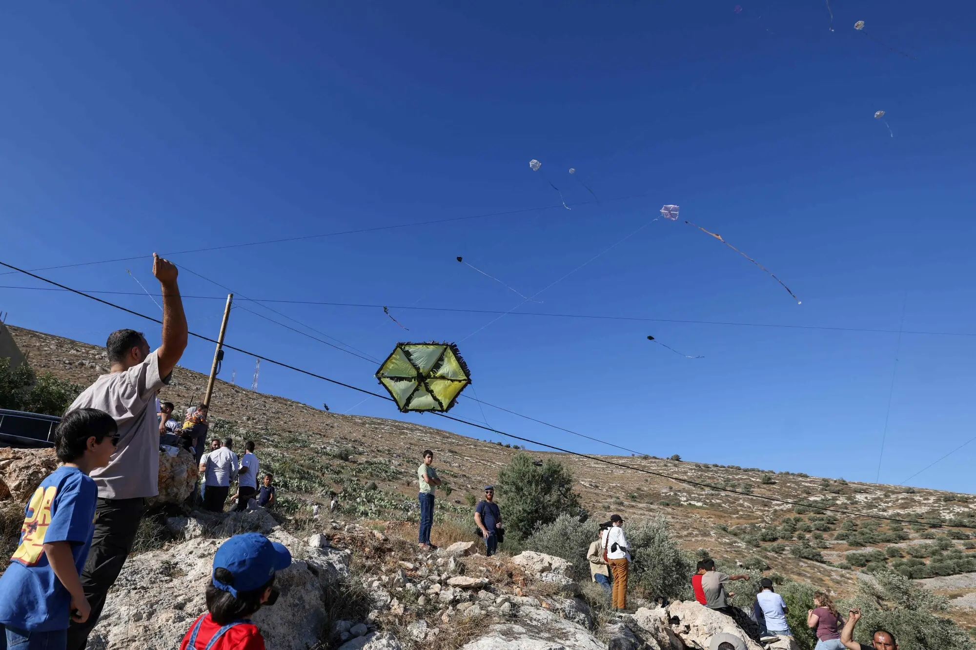 Palestinians and solidartiy activists fly kites towards the Israeli settelment of Har Bracha from the village of Burin, south of Nablus in the occupied West Bank on July 10, 2026. —AFP