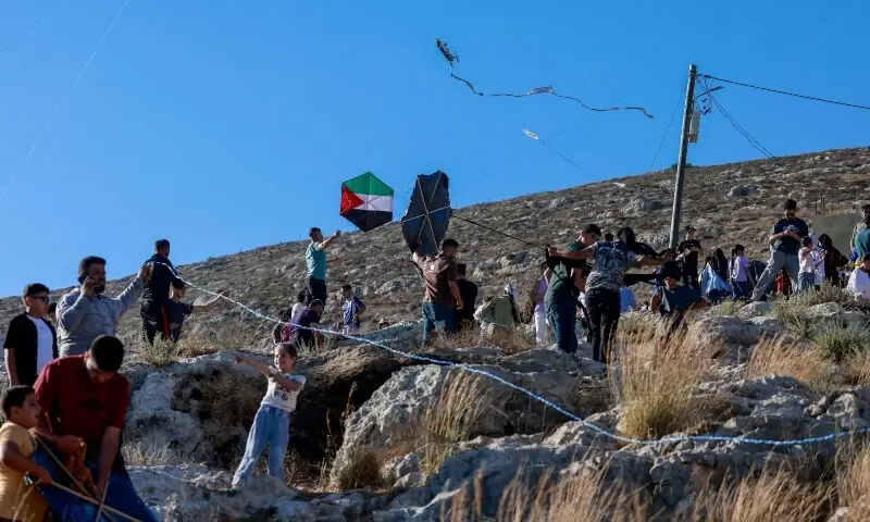 Palestinians and solidartiy activists fly kites towards the Israeli settelment of Har Bracha from the village of Burin, south of Nablus in the occupied West Bank on July 10, 2026. —AFP