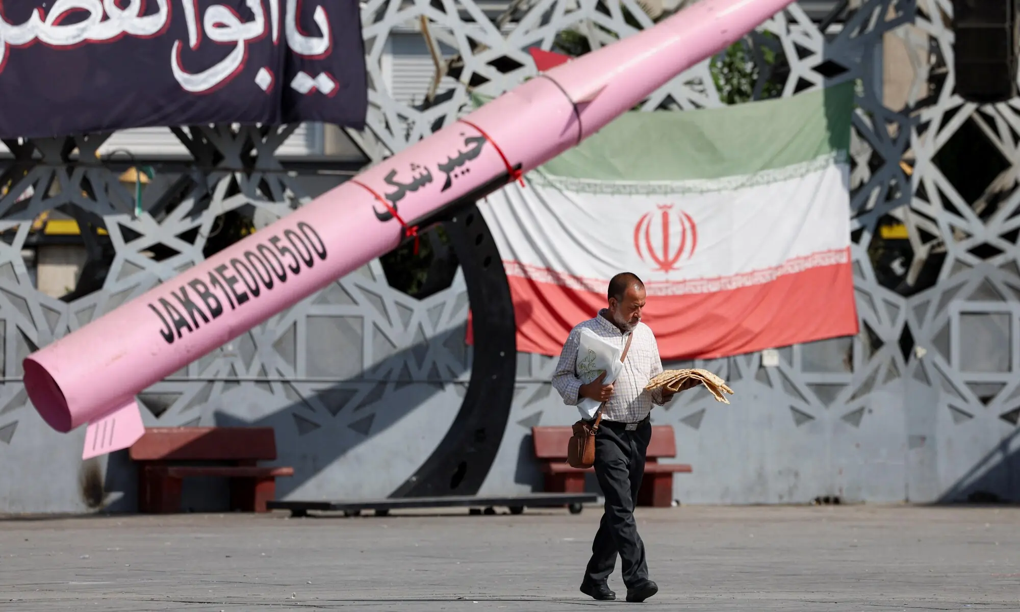 A man walks next to a symbolic mockup of an Iranian missile and an Iranian flag at Imam Hussein Square in Tehran, Iran, July 12, 2026. Majid Asgaripour/WANA (West Asia News Agency) via REUTERS ATTENTION EDITORS - THIS PICTURE WAS PROVIDED BY A THIRD PARTY. ISRAEL OUT. NO COMMERCIAL OR EDITORIAL SALES IN ISRAEL. NO ACCESS FOR ISRAELI MEDIA. NO USE BBC PERSIAN. NO USE VOA PERSIAN. NO USE MANOTO. NO USE IRAN INTERNATIONAL. NO USE RADIO FARDA. DIGITAL: NO USE BBC PERSIAN. NO USE VOA PERSIAN. NO USE MANOTO. NO U A man walks next to a symbolic mockup of an Iranian missile and an Iranian flag at Imam Hussein Square in Tehran, Iran, July 12, 2026. Majid Asgaripour/WANA (West Asia News Agency) via REUTERS ATTENTION EDITORS - THIS PICTURE WAS PROVIDED BY A THIRD PARTY. ISRAEL OUT. NO COMMERCIAL OR EDITORIAL SALES IN ISRAEL. NO ACCESS FOR ISRAELI MEDIA. NO USE BBC PERSIAN. NO USE VOA PERSIAN. NO USE MANOTO. NO USE IRAN INTERNATIONAL. NO USE RADIO FARDA. DIGITAL: NO USE BBC PERSIAN. NO USE VOA PERSIAN. NO USE MANOTO. NO U
