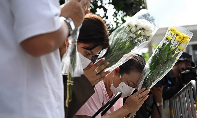 Relatives of a victim of a bar fire pray in front of the Rong Beer Na Lat Phrao bar in Bangkok on July 14, 2026. — AFP
