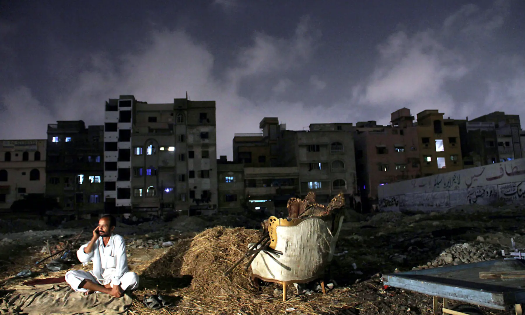 A man sits outside amid a power outage in Karachi. &mdash; White Star