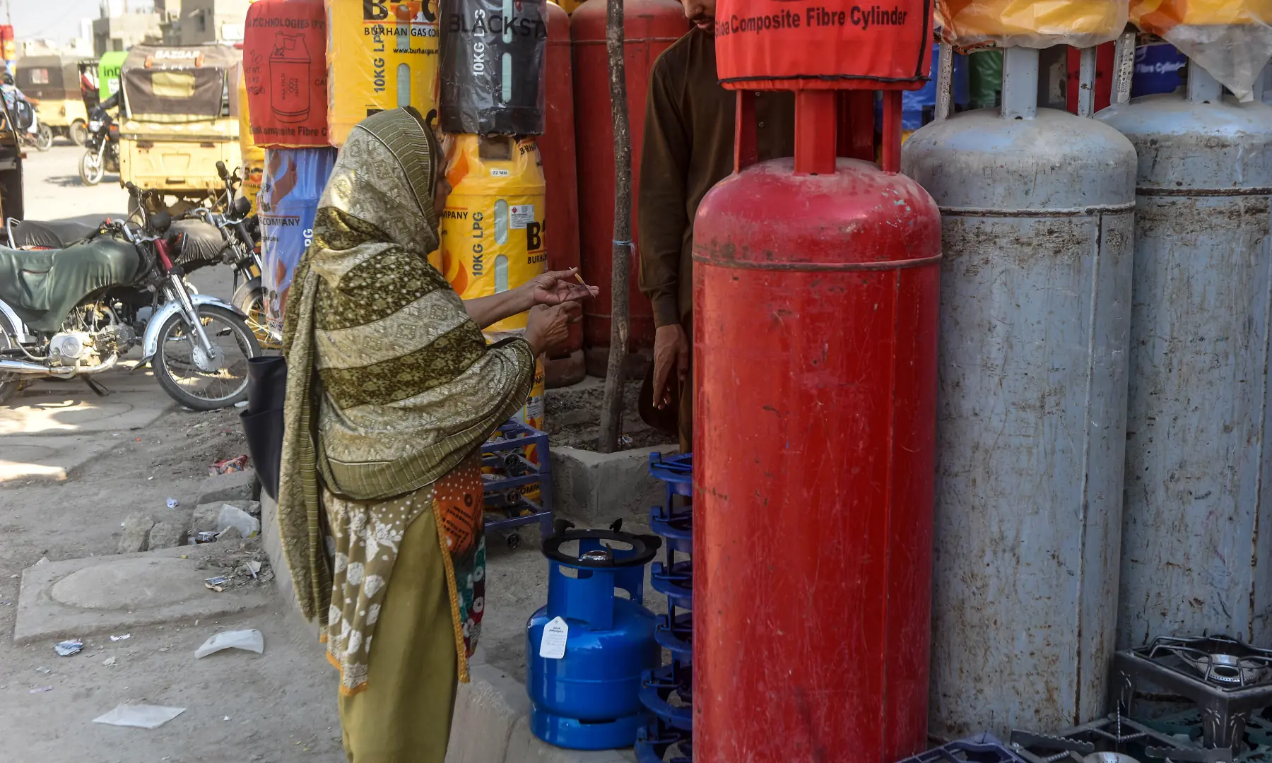 A woman buys a gas canister in Karachi. &mdash; White Star
