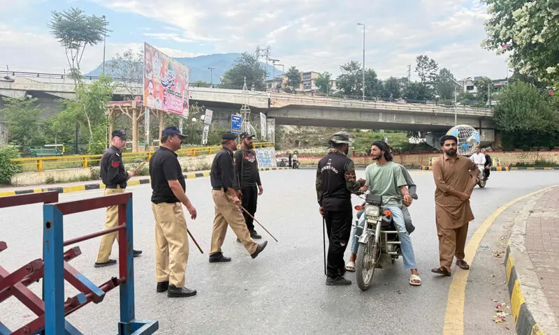 POLICE frisk people at a checkpoint in Muzaffarabad, the capital of AJK, where the situation has been tense in recent days because of the protests staged by the proscribed JAAC.—AFP POLICE frisk people at a checkpoint in Muzaffarabad, the capital of AJK, where the situation has been tense in recent days because of the protests staged by the proscribed JAAC.—AFP