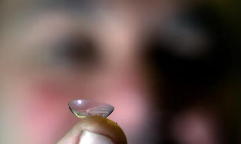 A doctor holds up a contact lens at his practice in this illustration. — Reuters A doctor holds up a contact lens at his practice in this illustration. — Reuters