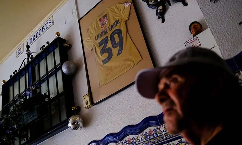 Pedro, 83, talks in front of a jersey of soccer player Lamine Yamal displaying on the wall of Bar El Cordobes at Rocafonda neighbourhood in Mataro, north of Barcelona, Spain on July 16, 2026. — Reuters