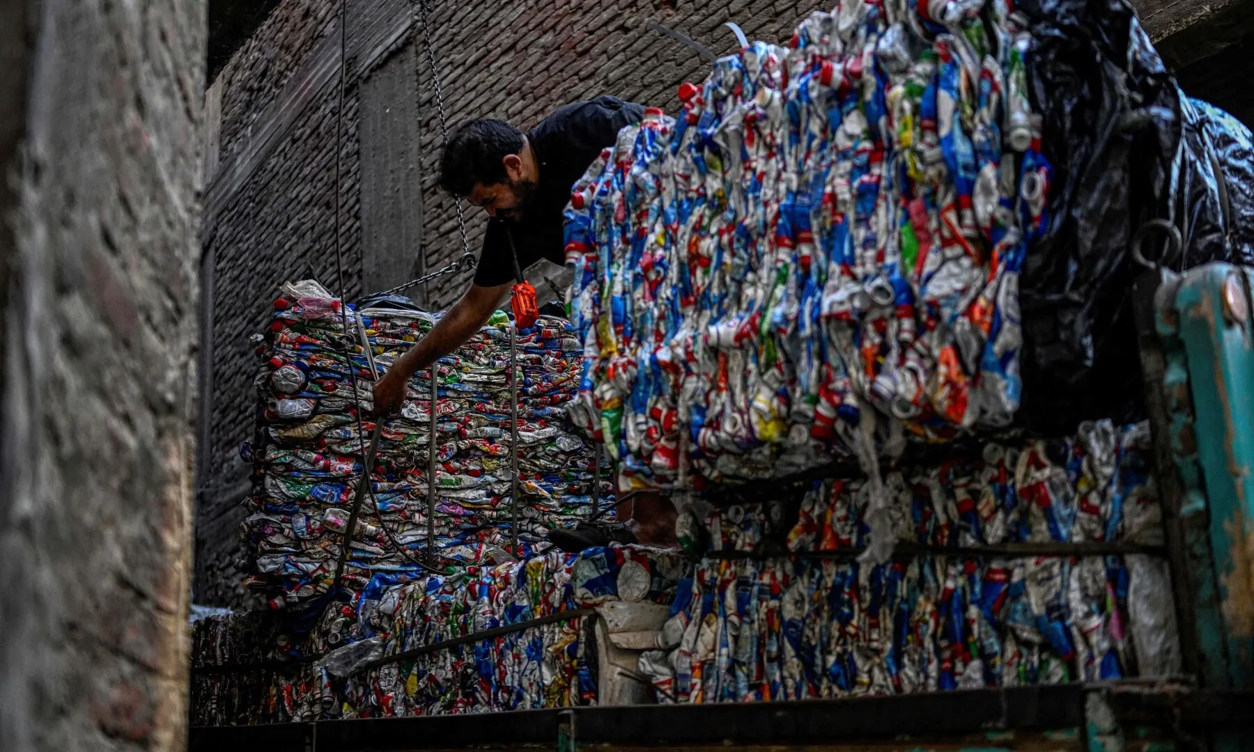 An Egyptian worker loads bails of plastic for recycling on a truck at the garbage city in the Manshiyet Nasser neighbourhood in Cairo on July 6, 2026. — AFP