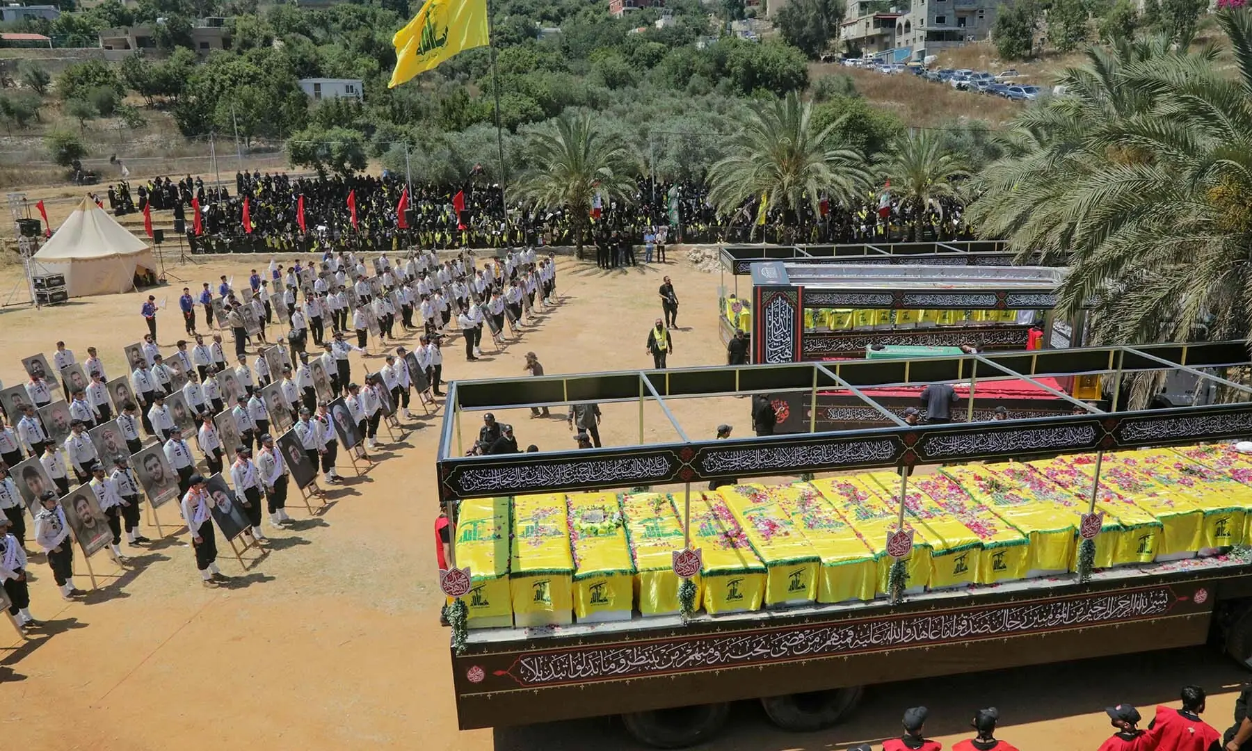 The caskets of Hezbollah fighters killed during clashes with the Israeli army are pictured to the right and left of a mock coffin of Iran’s slain supreme leader, Ayatollah Ali Khamenei, during a mass funeral in the southern Lebanese village of Majdel Selm on July 18, 2026. — AFP