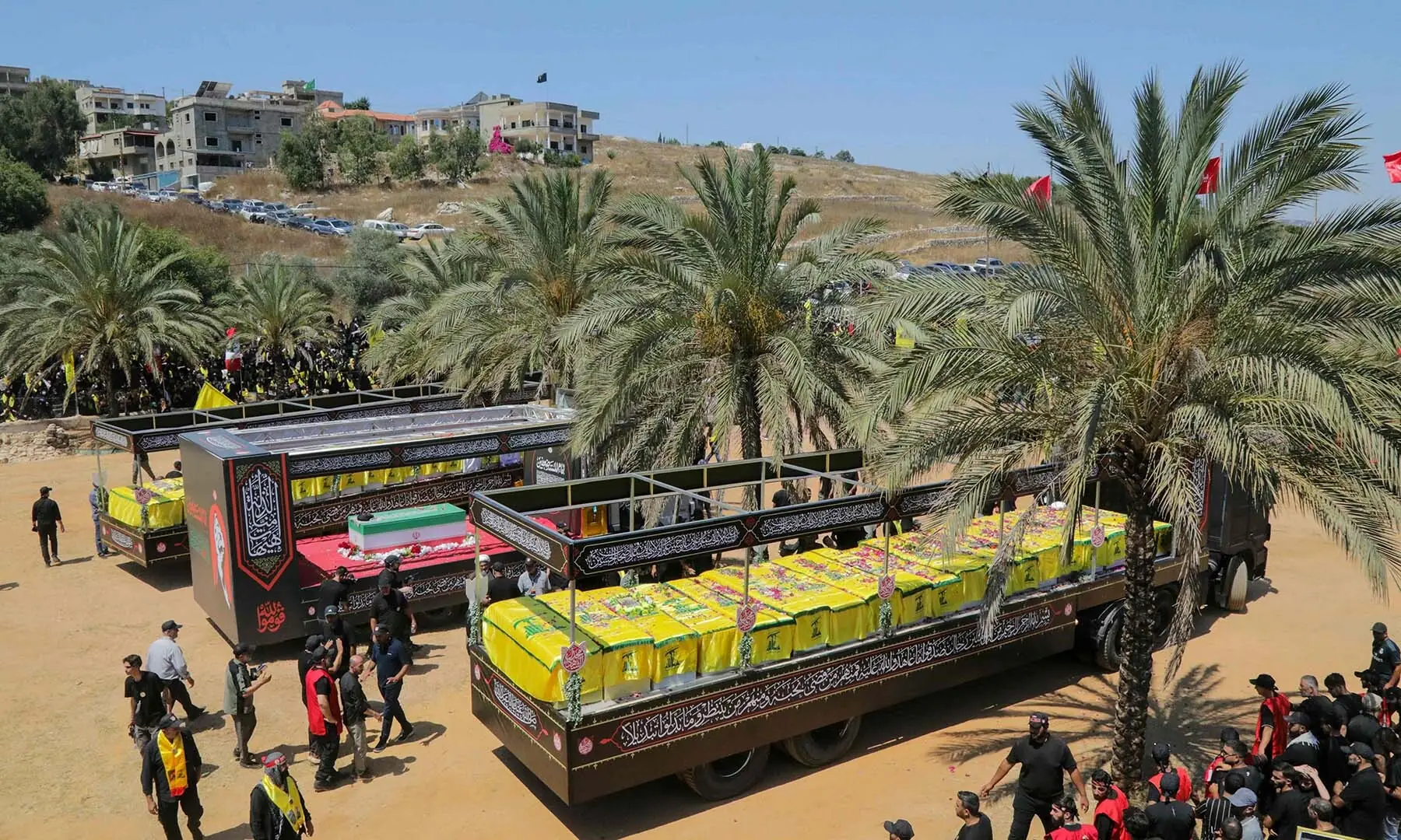 The caskets of Hezbollah fighters killed during clashes with the Israeli army are pictured to the right and left of a mock coffin of Iran&rsquo;s slain supreme leader, Ayatollah Ali Khamenei, during a mass funeral in the southern Lebanese village of Majdel Selm on July 18, 2026. &mdash; AFP
