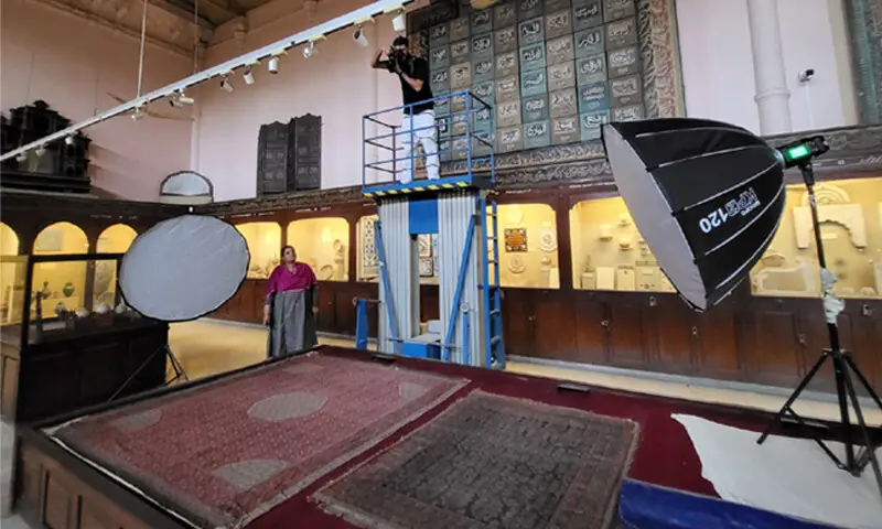 The photographing process of carpets in the Islamic Gallery at the Lahore Museum in 2024: fluctuating humidity levels and a lack of conservation work have led to the degradation of cloth artefacts on display at the museum | Photo courtesy Ayesha Iftikhar The photographing process of carpets in the Islamic Gallery at the Lahore Museum in 2024: fluctuating humidity levels and a lack of conservation work have led to the degradation of cloth artefacts on display at the museum | Photo courtesy Ayesha Iftikhar