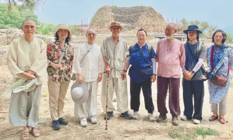 A Korean delegation, led by the Most Venerable Monk Jong Lim, poses for a group photo at the ancient Buddhist site of Dharmarajika Stupa near Taxila on Sunday. — Dawn A Korean delegation, led by the Most Venerable Monk Jong Lim, poses for a group photo at the ancient Buddhist site of Dharmarajika Stupa near Taxila on Sunday. — Dawn