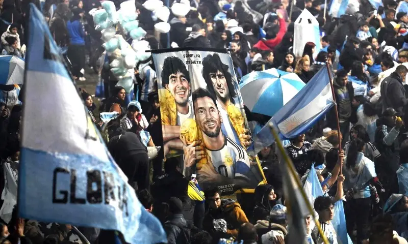 Fans hold a banner depicting Argentine football legends Diego Maradona, Mario Kempes and Lionel Messi holding FIFA World Cup trophies as supporters gather near the Argentine Football Association (AFA) training camp in Ezeiza, Buenos Aires Province, on July 20, 2026, while awaiting the arrival of Argentina's national football team from the United States following its defeat in the 2026 FIFA World Cup final. — AFP Fans hold a banner depicting Argentine football legends Diego Maradona, Mario Kempes and Lionel Messi holding FIFA World Cup trophies as supporters gather near the Argentine Football Association (AFA) training camp in Ezeiza, Buenos Aires Province, on July 20, 2026, while awaiting the arrival of Argentina's national football team from the United States following its defeat in the 2026 FIFA World Cup final. — AFP