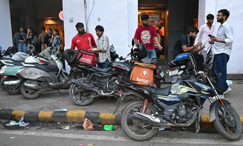 Food-delivery gig workers park by a roadside near the Jantar Mantar in New Delhi on July 22, 2026 during an ongoing protest by Cockroach Janta Party (CJP) demanding the resignation of India's Education Minister Dharmendra Pradhan over alleged NEET exam irregularities. — AFP Food-delivery gig workers park by a roadside near the Jantar Mantar in New Delhi on July 22, 2026 during an ongoing protest by Cockroach Janta Party (CJP) demanding the resignation of India's Education Minister Dharmendra Pradhan over alleged NEET exam irregularities. — AFP