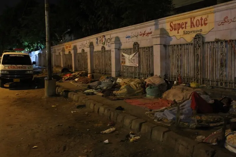 Patients and their attendants sleep on the footpath opposite the SIUT Karachi. &mdash;Dawn/File