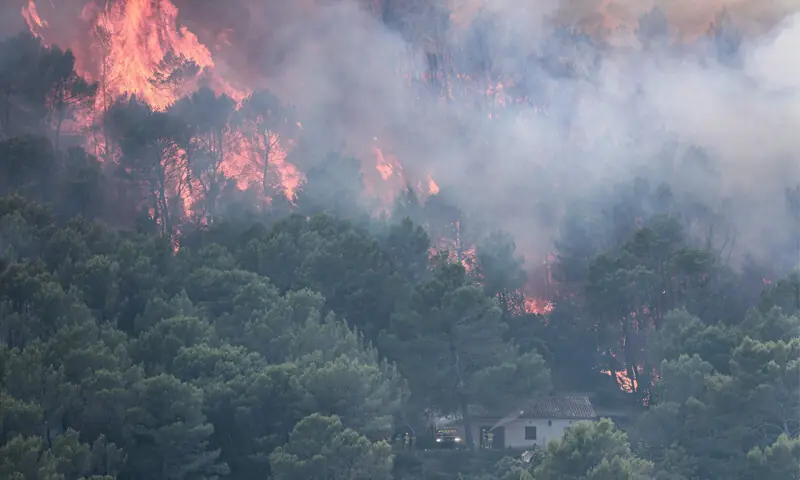 SMOKE and flames from a wildfire near a building in Cotignac, south-eastern France.&mdash;AFP