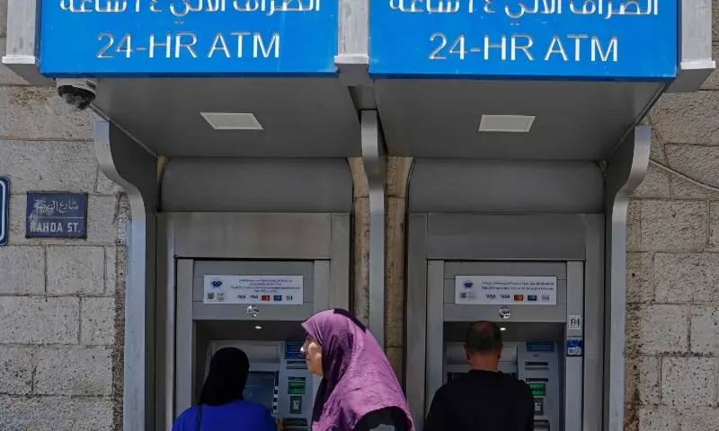 Palestinians withdraw money from the ATM of a bank in Ramallah, in the Israeli-occupied West Bank on July 23, 2026. &mdash; AFP