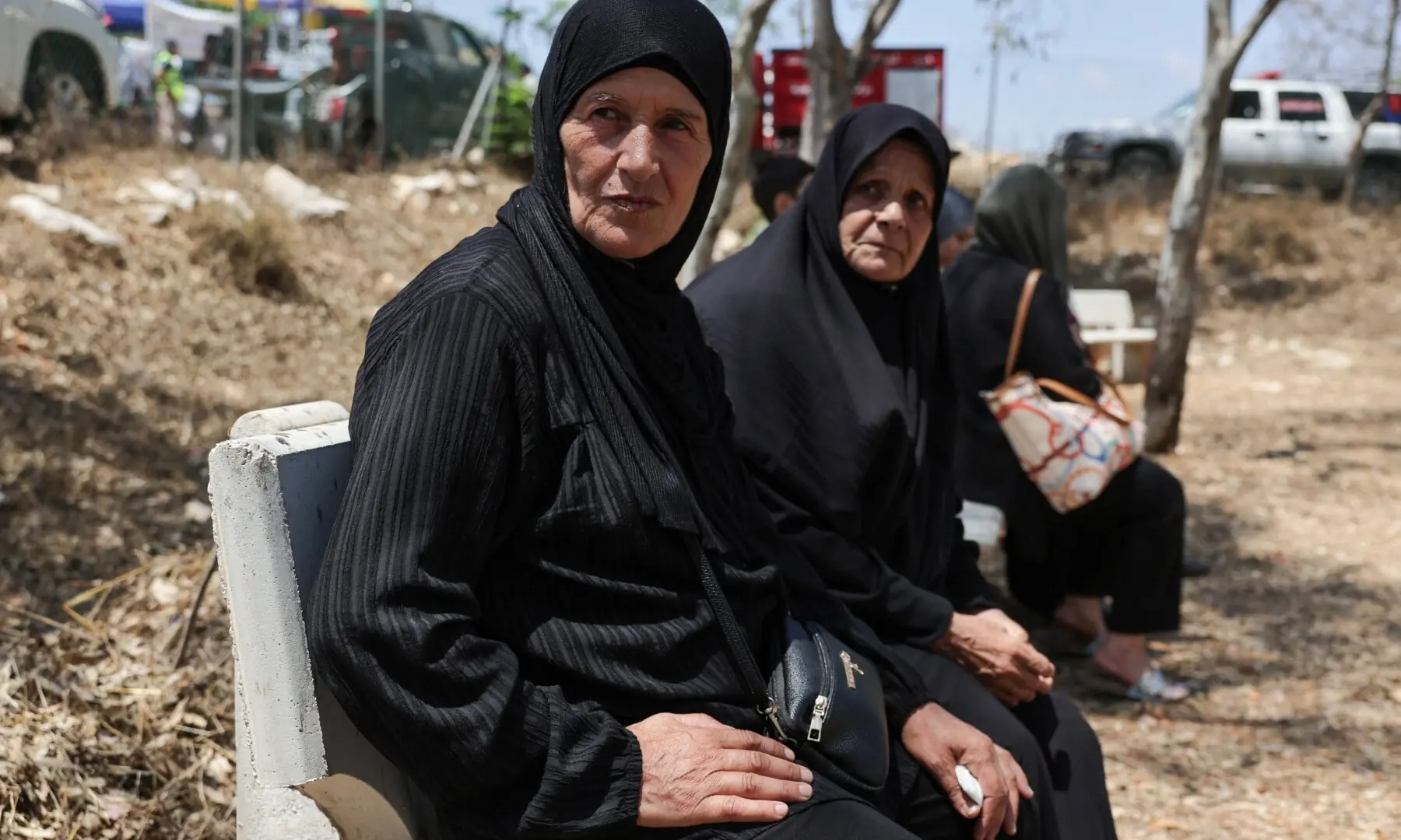 Wafaa Ismail and her friend Alia Abu Zed, both working in tobacco fields, wait for permission to enter Zawtar al-Gharbiyeh village, following the withdrawal of Israeli forces under a US-brokered plan, in southern Lebanon, on July 23, 2026. &mdash; Reuters