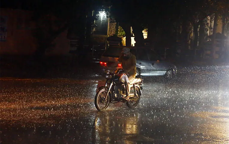 A motorcyclist heads home as many areas received a brief spell of rain on Friday night.—Shakil Adil / White Star A motorcyclist heads home as many areas received a brief spell of rain on Friday night.—Shakil Adil / White Star