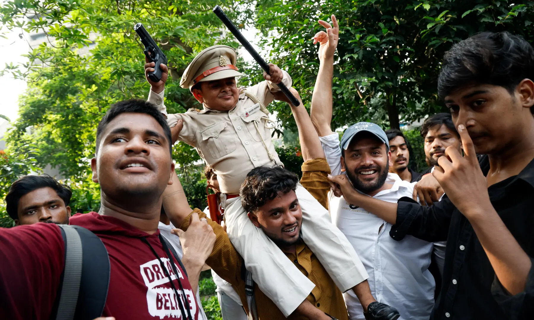  A man carries a child as supporters of India’s Cockroach Janta Party (CJP) celebrate after India’s Education Minister Dharmendra Pradhan resigned, in New Delhi on July 25, 2026. — Reuters 