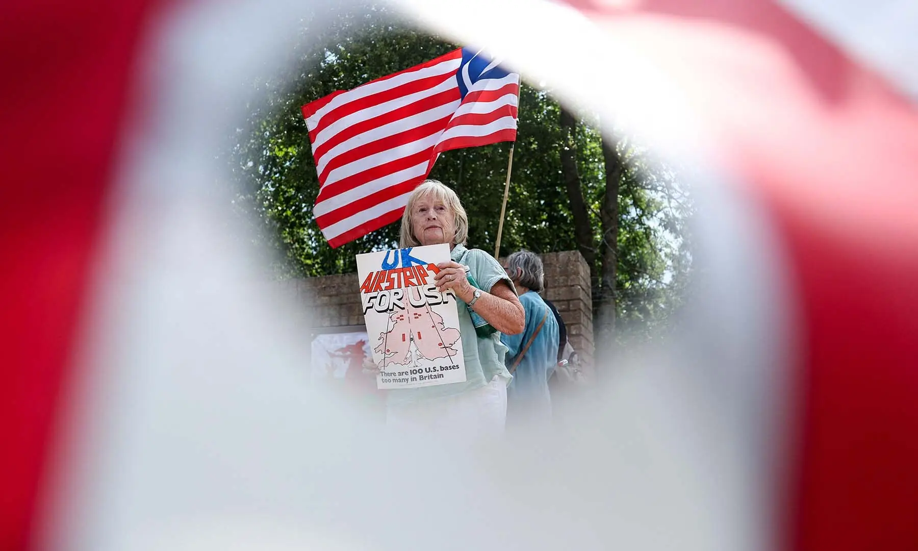 A woman attends an anti-war demonstration outside the main gate of RAF Fairford airbase, which hosts US Air Force personnel in Fairford, Gloucestershire, the UK on July 25, 2026. &mdash; Reuters