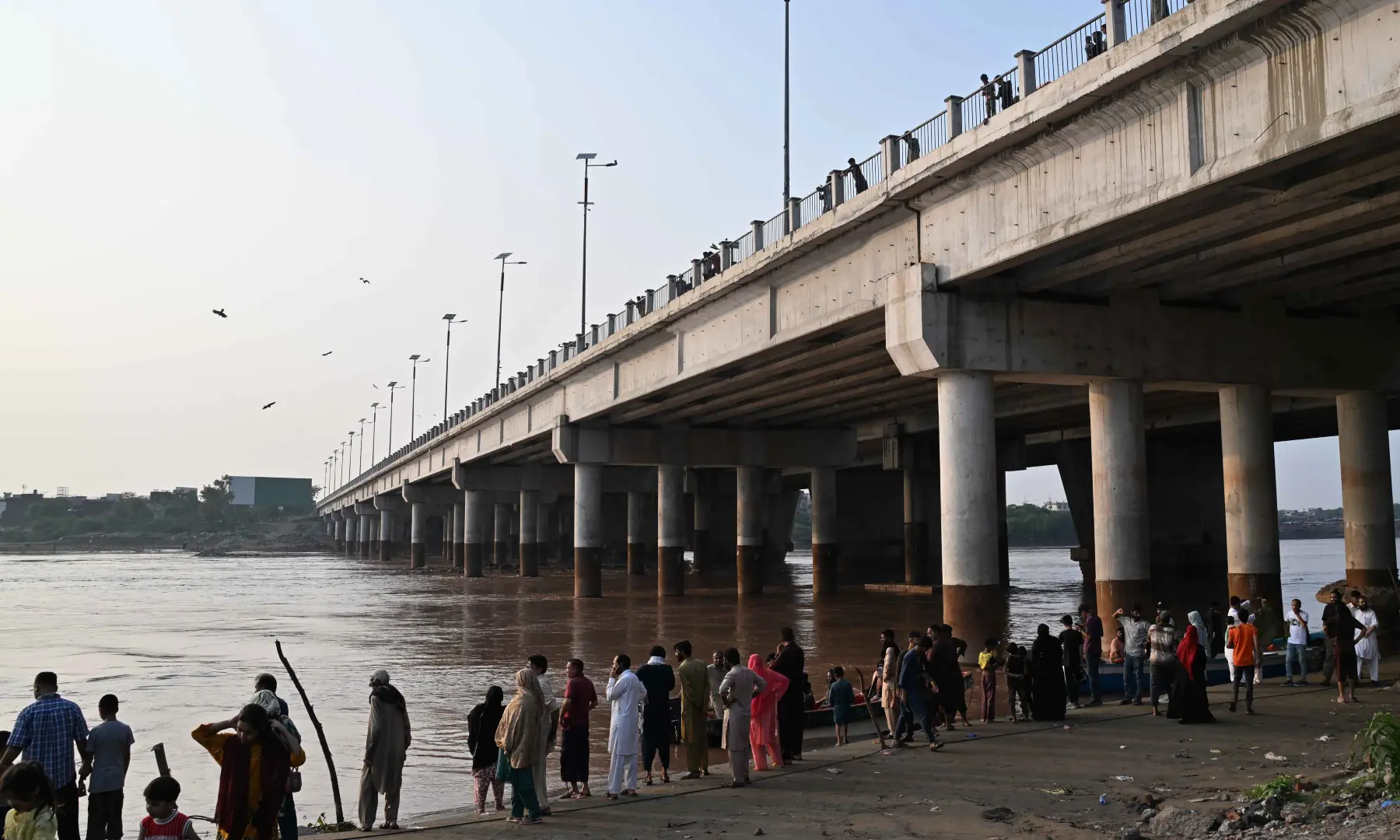 People look over water levels at River Ravi that have risen, on July 26, 2026. — Arif Ali/White Star People look over water levels at River Ravi that have risen, on July 26, 2026. — Arif Ali/White Star