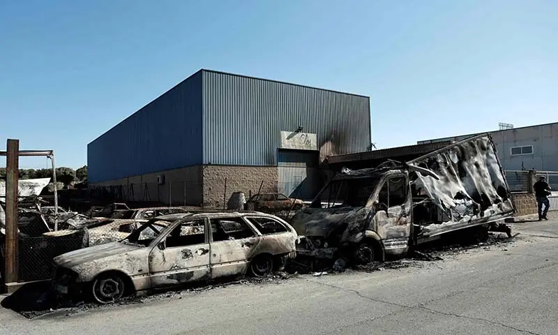 Burnt-out vehicles are seen in an industrial estate following a wildfire in Chapineria, 50 kilometres west of Madrid, on July 27, 2026. — AFP