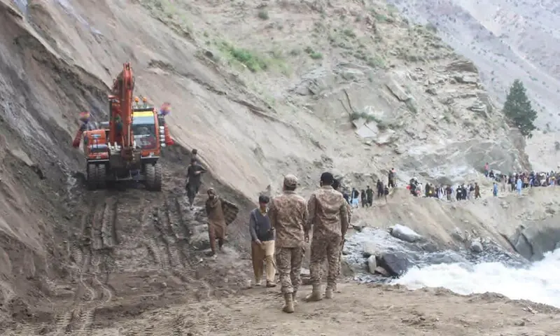 people cross a blocked section of the Astore Valley road on foot as repair work continues.&mdash;Photo by the writer