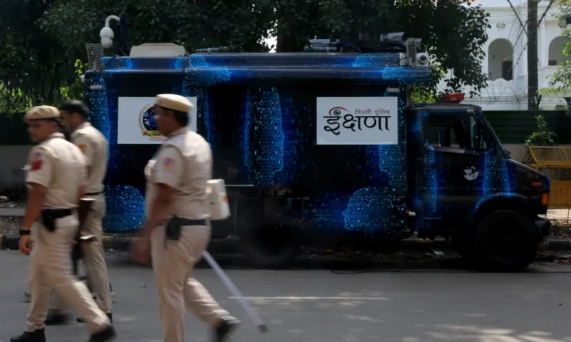 Police officers move past Ikshana, a mobile surveillance van, parked at the ongoing protest site, days after thousands of the supporters of India's Cockroach Janta Party (CJP) marched towards parliament demanding the resignation of Education Minister Dharmendra Pradhan over National Eligibility-cum-Entrance Test (NEET) examination paper leaks, at Jantar Mantar in New Delhi on July 25, 2026. &mdash; Reuters
