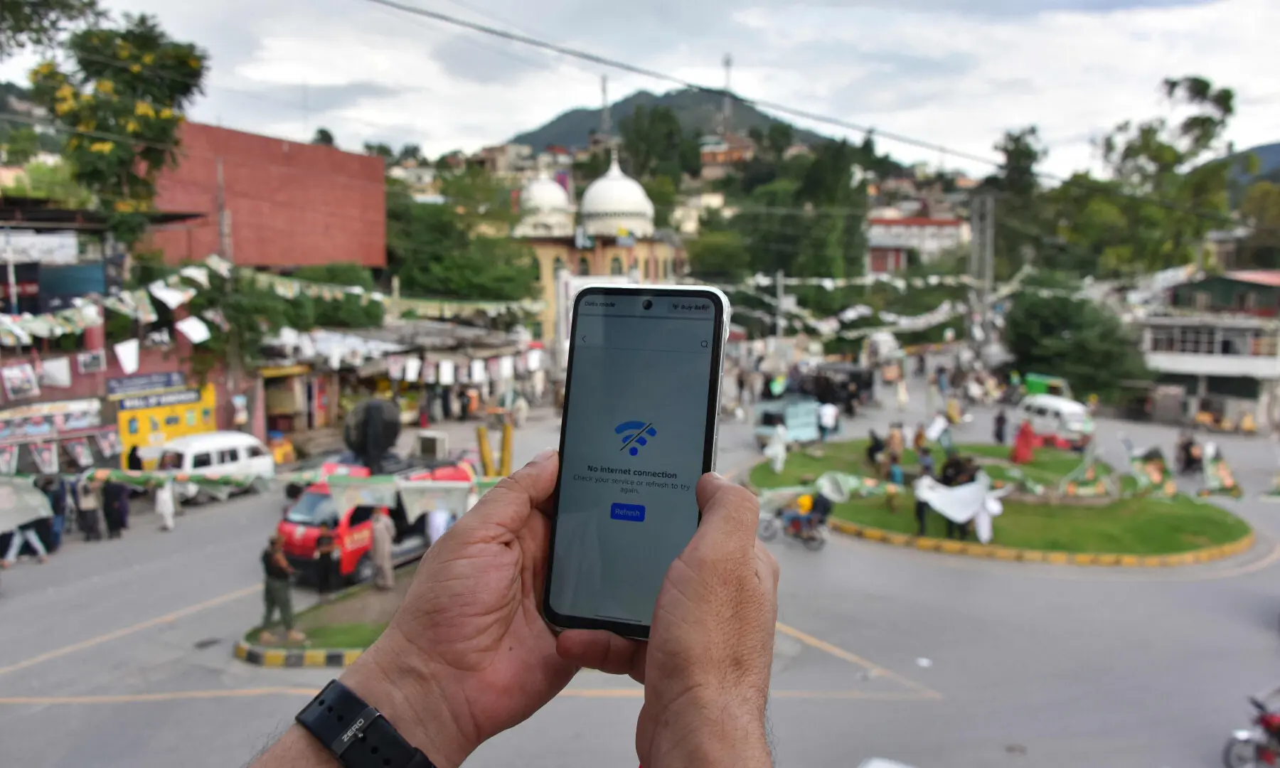 This photograph taken on July 23, 2026 shows a youth searching for mobile phone signals following a partial internet shutdown imposed ahead of the first phase of the regional elections in AJK's Muzaffarabad. &mdash; AFP/File