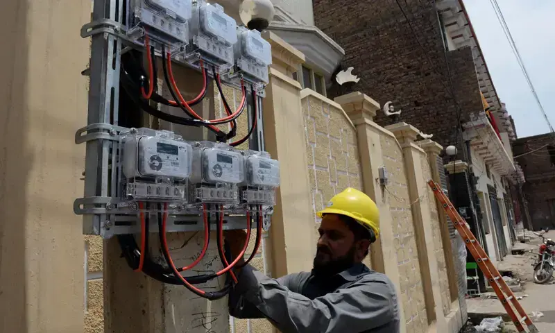 Worker setting up an electricity meter. &mdash;Dawn/File