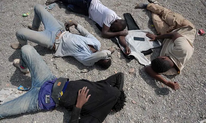 Migrants lie on Trampolin beach, as they await entry to the CETI short-stay migrant center in the Spanish North African enclave of Ceuta, on August 1, 2026. — AFP