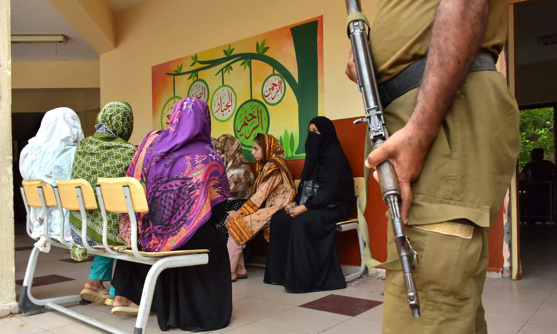 A policeman stands guard as women voters wait to cast their ballots at a polling station during the second phase of elections for the local legislative assembly in Muzaffarabad on Aug 2, 2026. &mdash; AFP