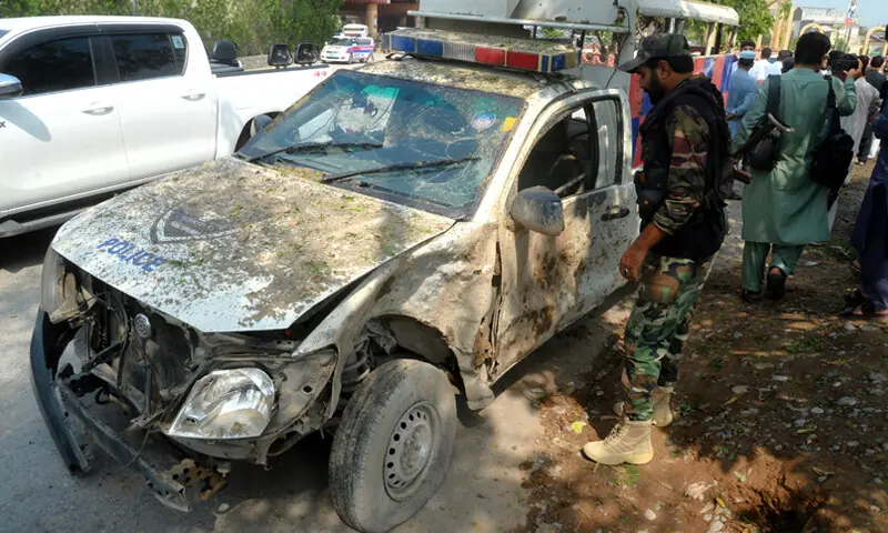 A security official inspects a police vehicle damaged in a roadside blast on GT Road, Peshawar, on Sunday. — White Star A security official inspects a police vehicle damaged in a roadside blast on GT Road, Peshawar, on Sunday. — White Star