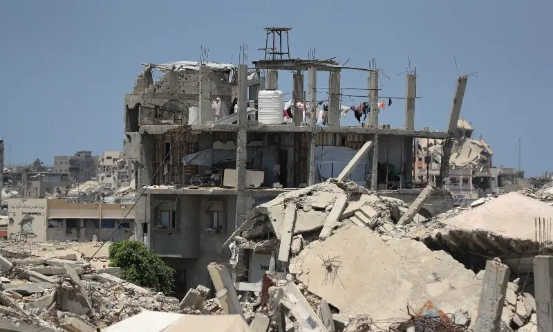 A Palestinian woman stands on the roof of a house damaged during the war, surrounded by destroyed buildings, in Gaza City on August 1, 2026. — Reuters A Palestinian woman stands on the roof of a house damaged during the war, surrounded by destroyed buildings, in Gaza City on August 1, 2026. — Reuters