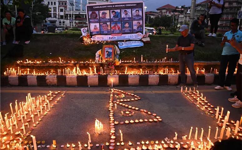 Mourners light candles before portraits of mountaineer Nirmal Purja and his companions during a memorial ceremony in Kathmandu.—AFP Mourners light candles before portraits of mountaineer Nirmal Purja and his companions during a memorial ceremony in Kathmandu.—AFP