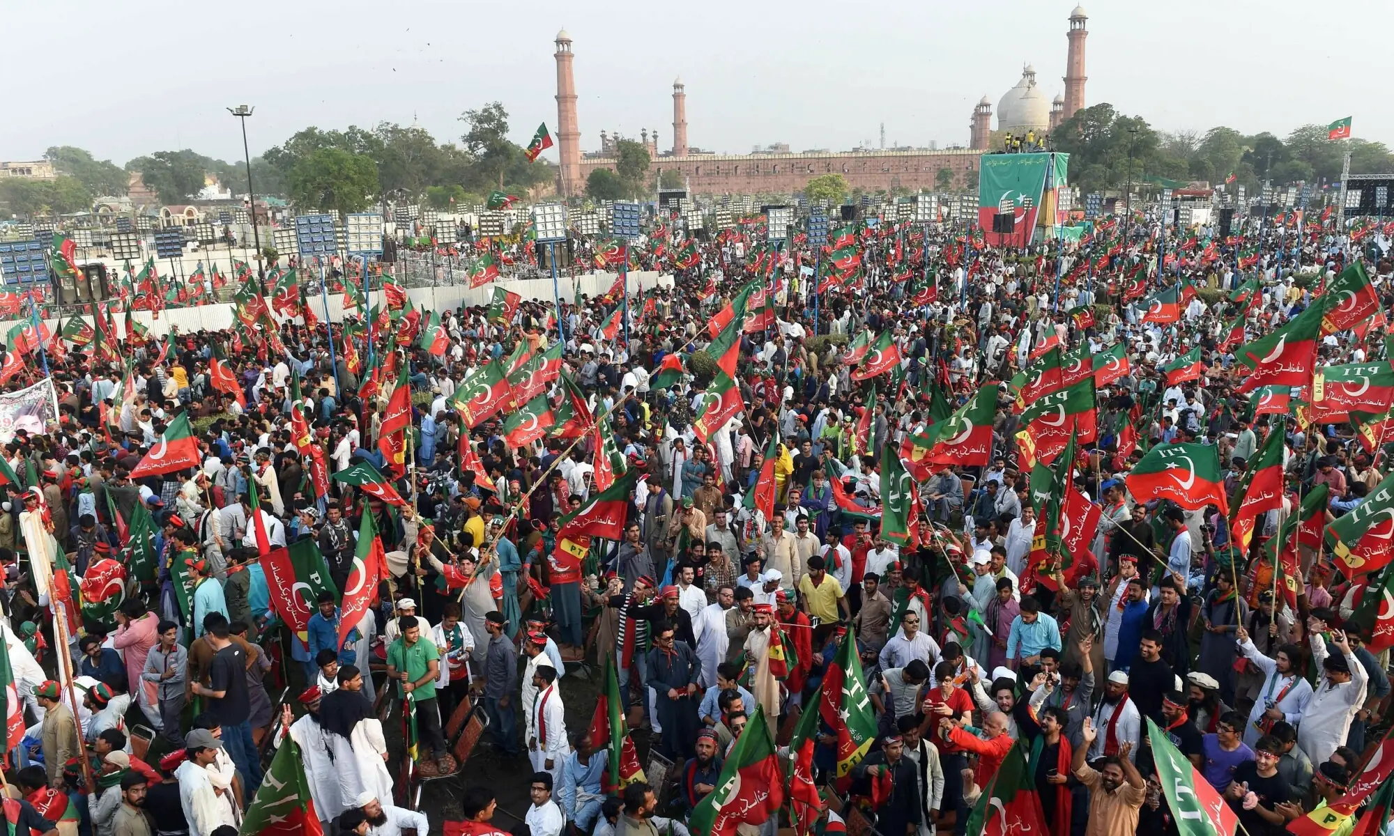 In this file photo, supporters gesture and wave PTI flags as they attend a rally in Lahore. &mdash;AFP/File