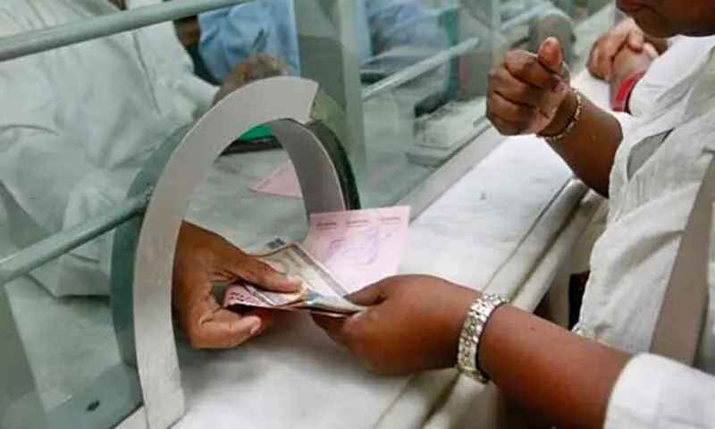 A person at a bank counter can be seen in this file photo. — AFP/File A person at a bank counter can be seen in this file photo. — AFP/File