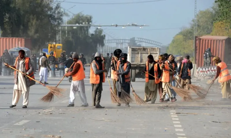 CDA workers sweep Islamabad Expressway. — White Star/File CDA workers sweep Islamabad Expressway. — White Star/File