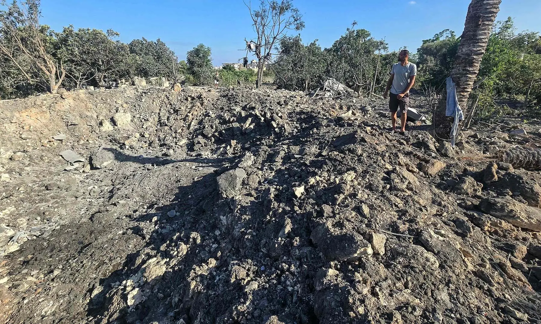A man stands by a crater left by an overnight Israeli airstrike that targeted a house in the area of Burj al-Shamali, near Tyre in southern Lebanon, on August 6, 2026. &mdash; AFP