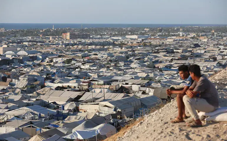 Palestinians sit on a hill overlooking a tent camp sheltering displaced people, in Khan Younis, southern Gaza Strip. — Reuters/File Palestinians sit on a hill overlooking a tent camp sheltering displaced people, in Khan Younis, southern Gaza Strip. — Reuters/File