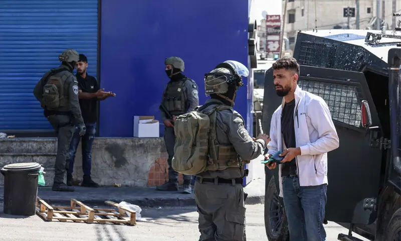 Israeli soldiers check documents of a Palestinian during a raid on the Qalandia refugee camp, in the occupied West Bank.&mdash;AFP