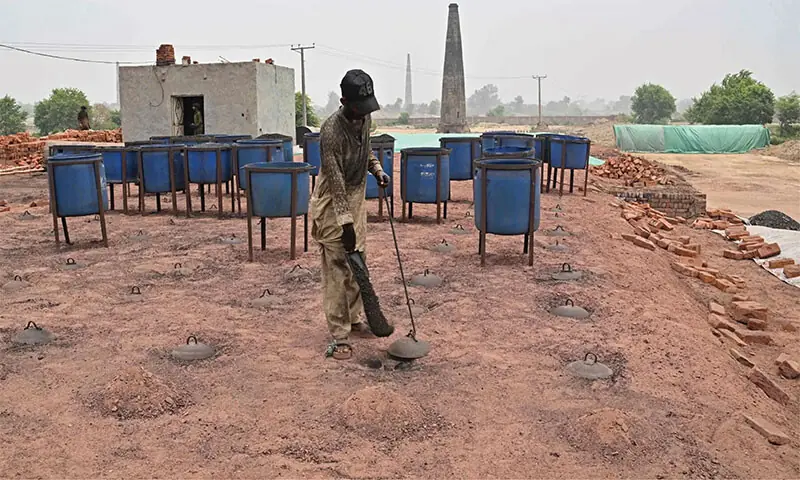 A man works at a brick kiln in Sheikhupura. —AFP A man works at a brick kiln in Sheikhupura. —AFP