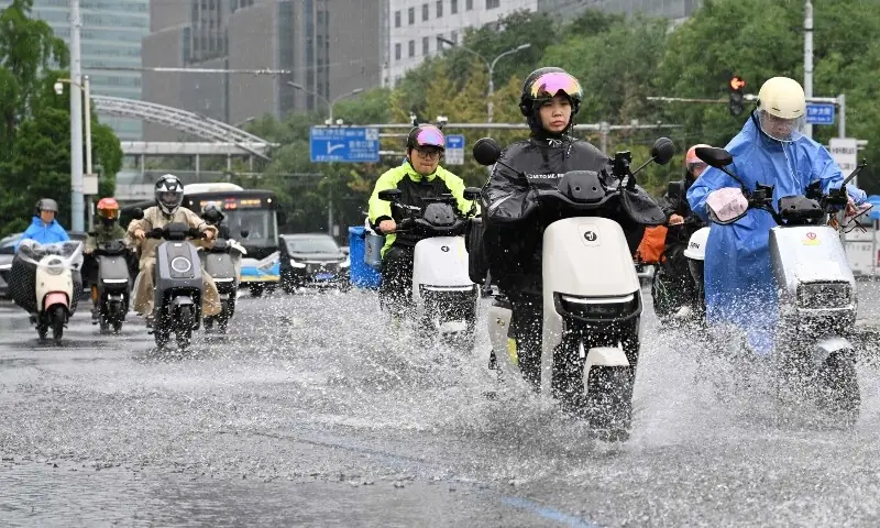 Commuters ride on a rainy day in Beijing on August 12, 2026. — AFP Commuters ride on a rainy day in Beijing on August 12, 2026. — AFP