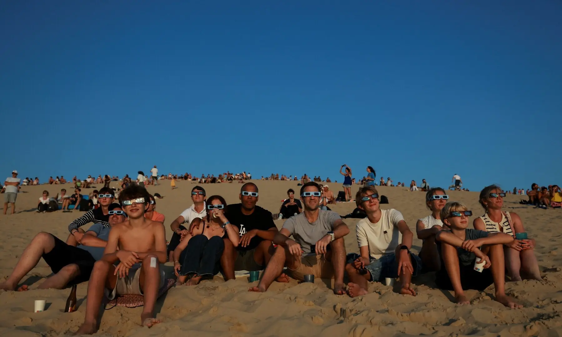  People watch a partial solar eclipse through protective glasses from the Dune of Pilat in La Teste-de-Buch near Arcachon, France, August 12, 2026. —Reuters 