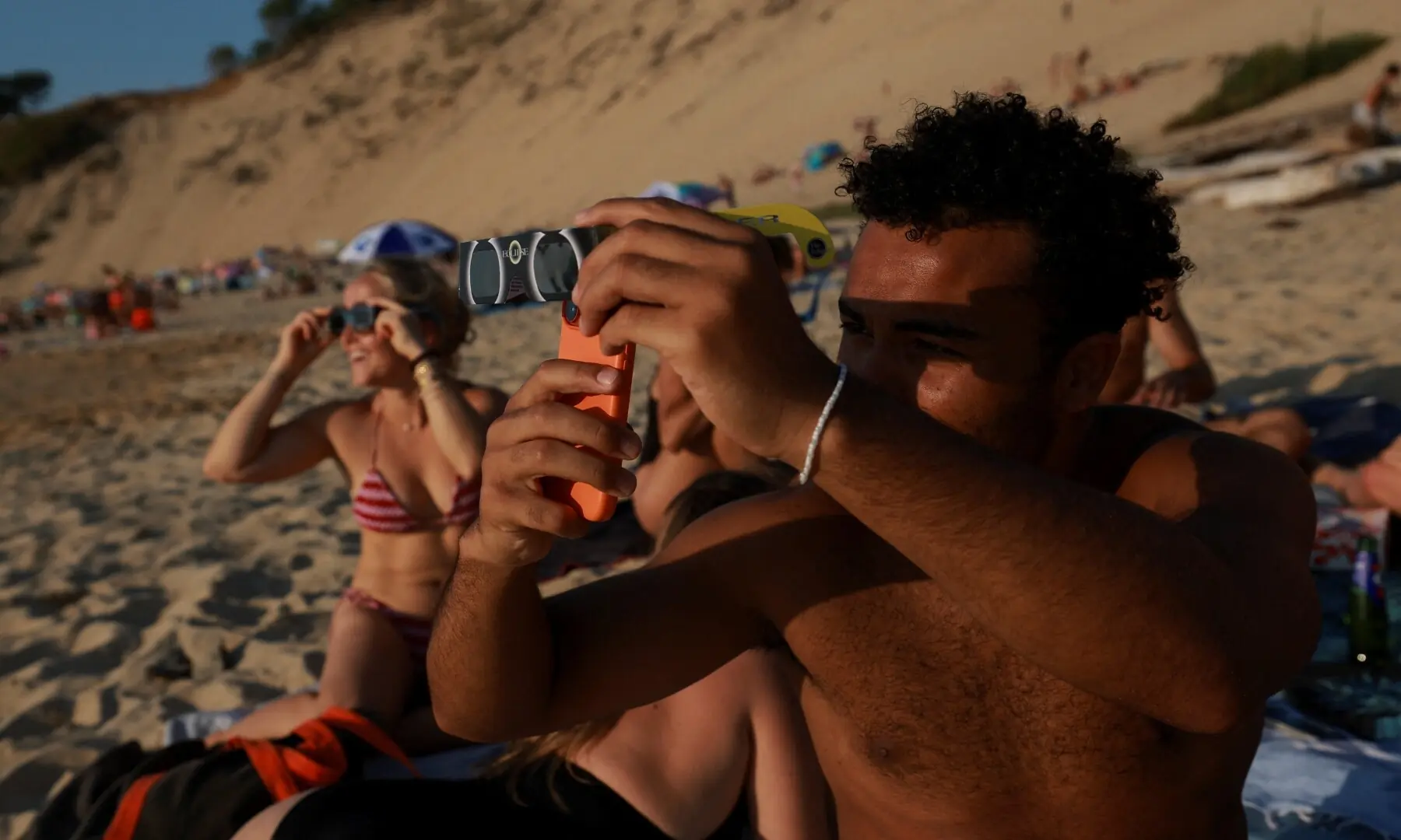  A family watches the partial solar eclipse through a mask and special glasses above Prachatice city, Czech Republic, on August 12, 2026. —AFP 