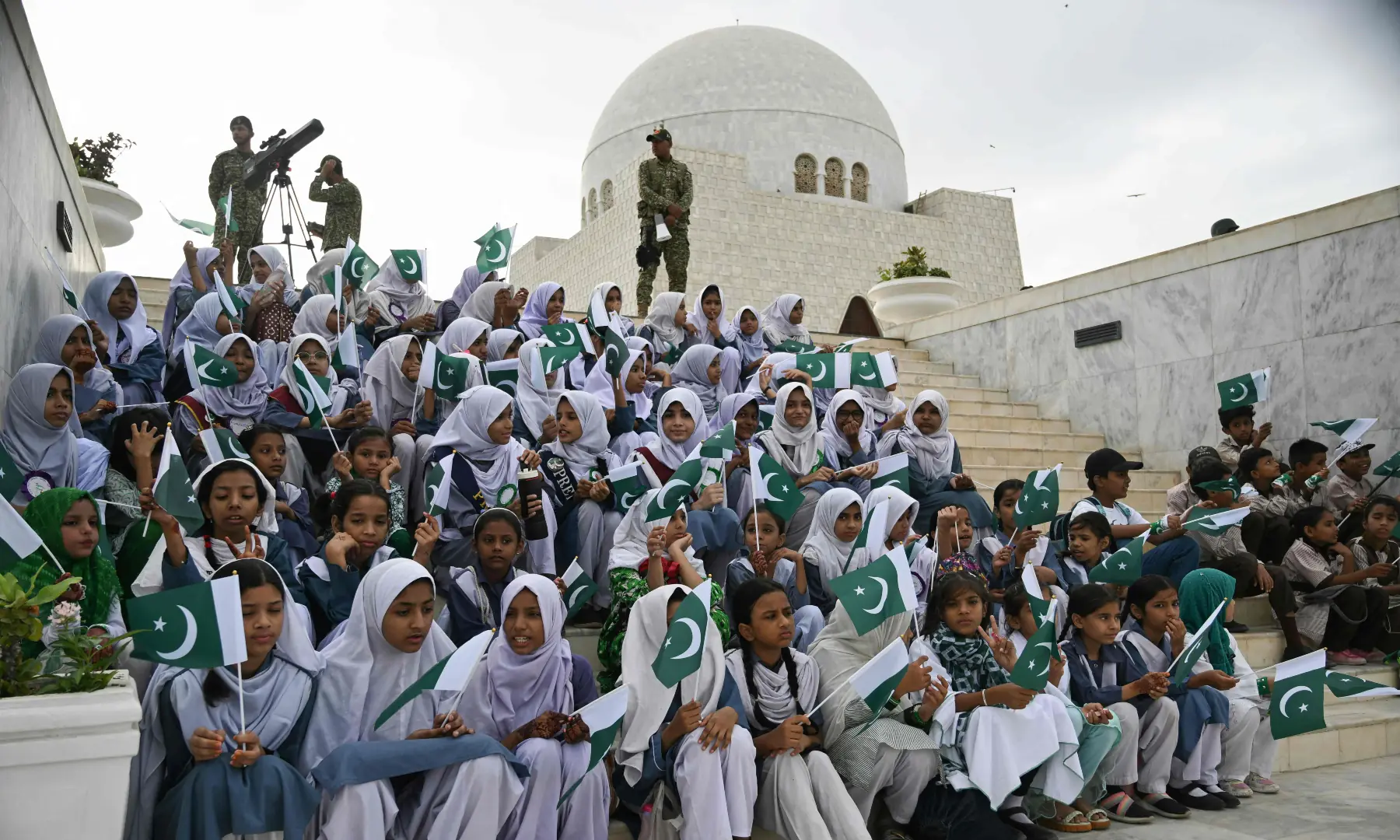 Students hold Pakistani national flags during Independence Day celebrations at the mausoleum of Quaid-i-Azam Muhammad Ali Jinnah in Karachi on August 14, 2026. &mdash; AFP
