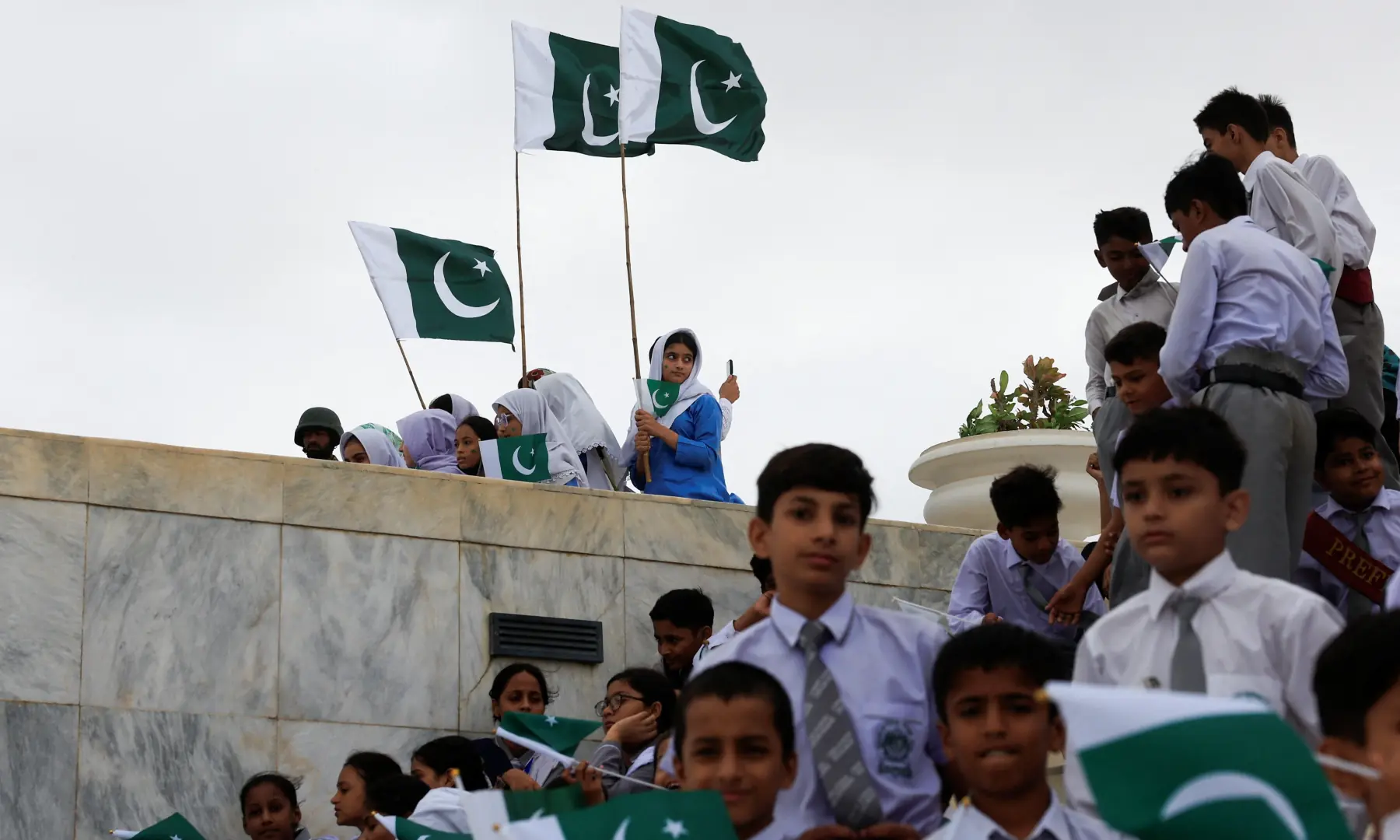 Attendees wave Pakistani flags during Independence Day celebrations at the mausoleum of Quaid-i-Azam Muhammad Ali Jinnah, in Karachi on August 14, 2026. — Reuters