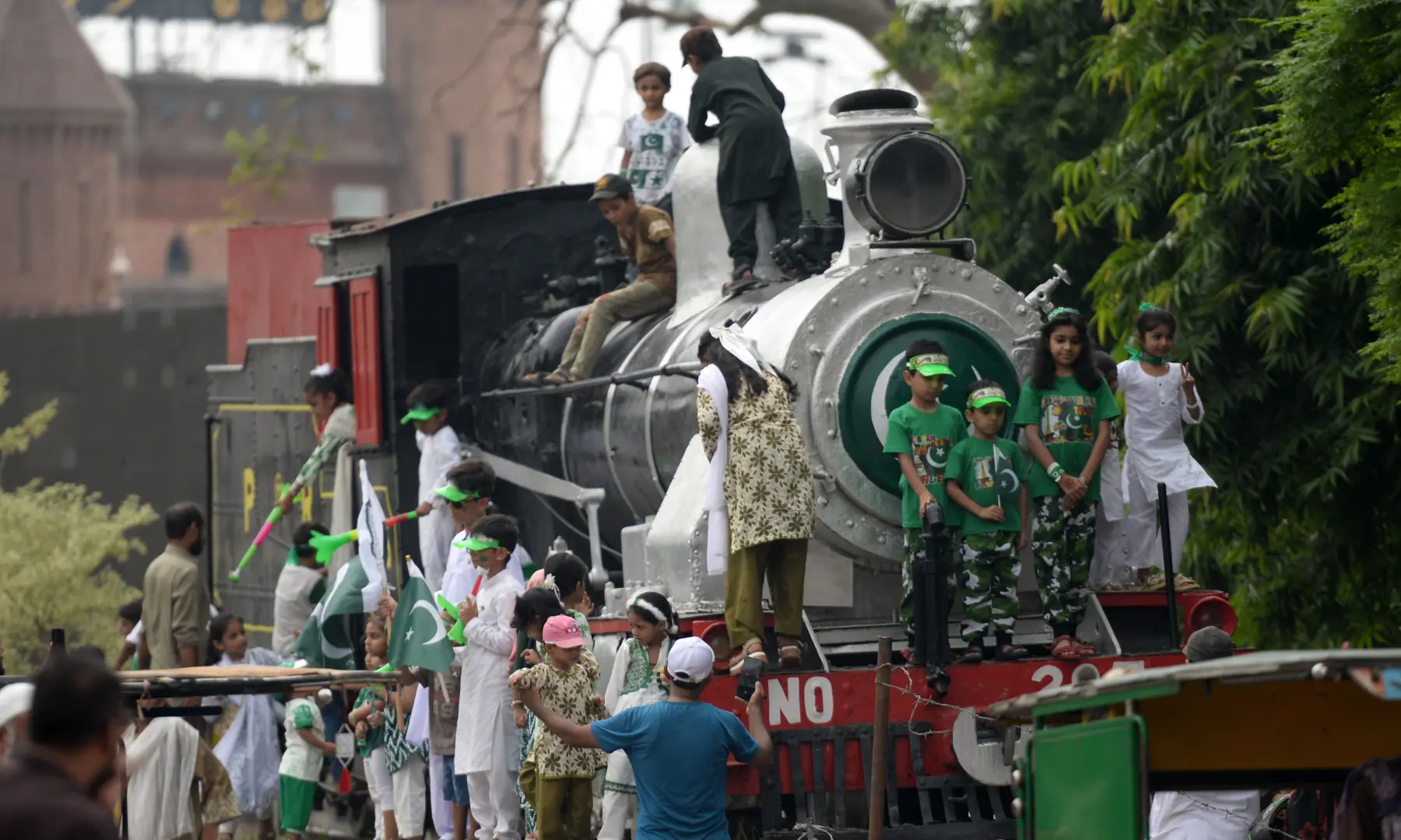 Children stand on and around a railway engine at a railway station in Lahore on Aug 14, 2026. — White Star